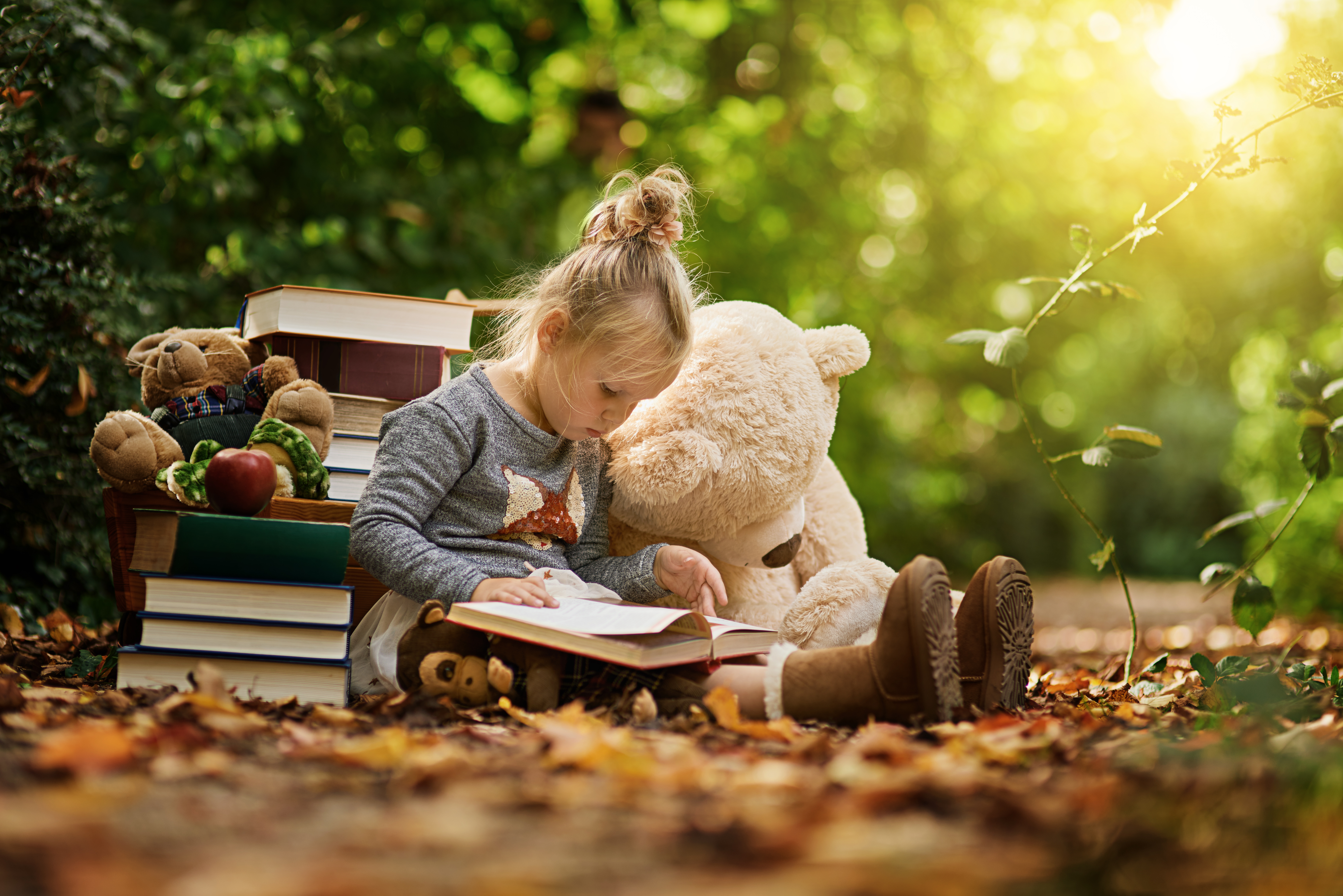 Girl reading to stuffed bear