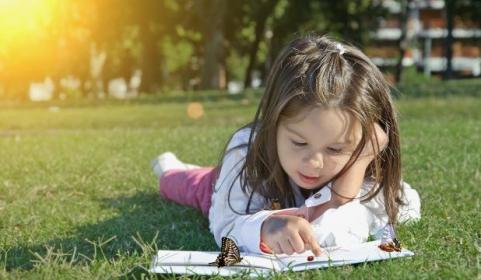 Young girl reading in the grass