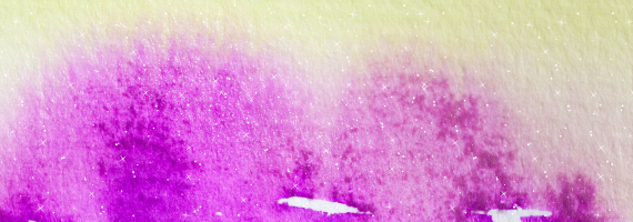 Close up image of a canvas with purple and yellow watercolor paint.