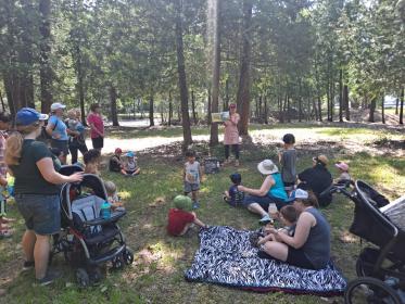 storytime group reading a book in the forest