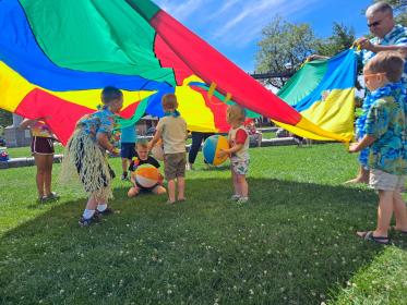 kids under a colorful parachute