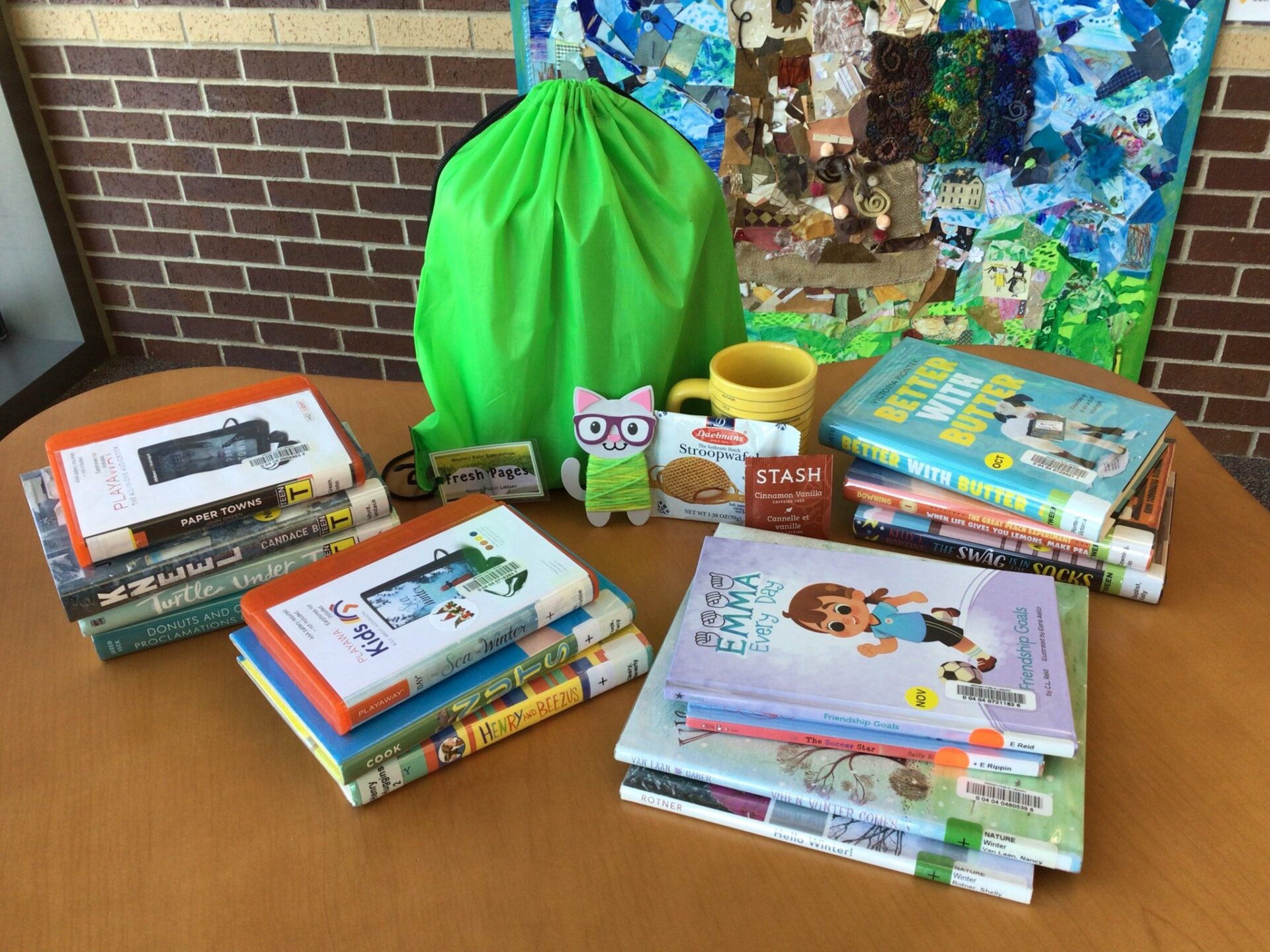 Fresh Pages bag with some of the fun items you might get in your bag, including books of a a variety of levels, a craft, and a treat